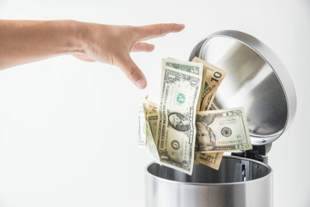 Hand throwing money away